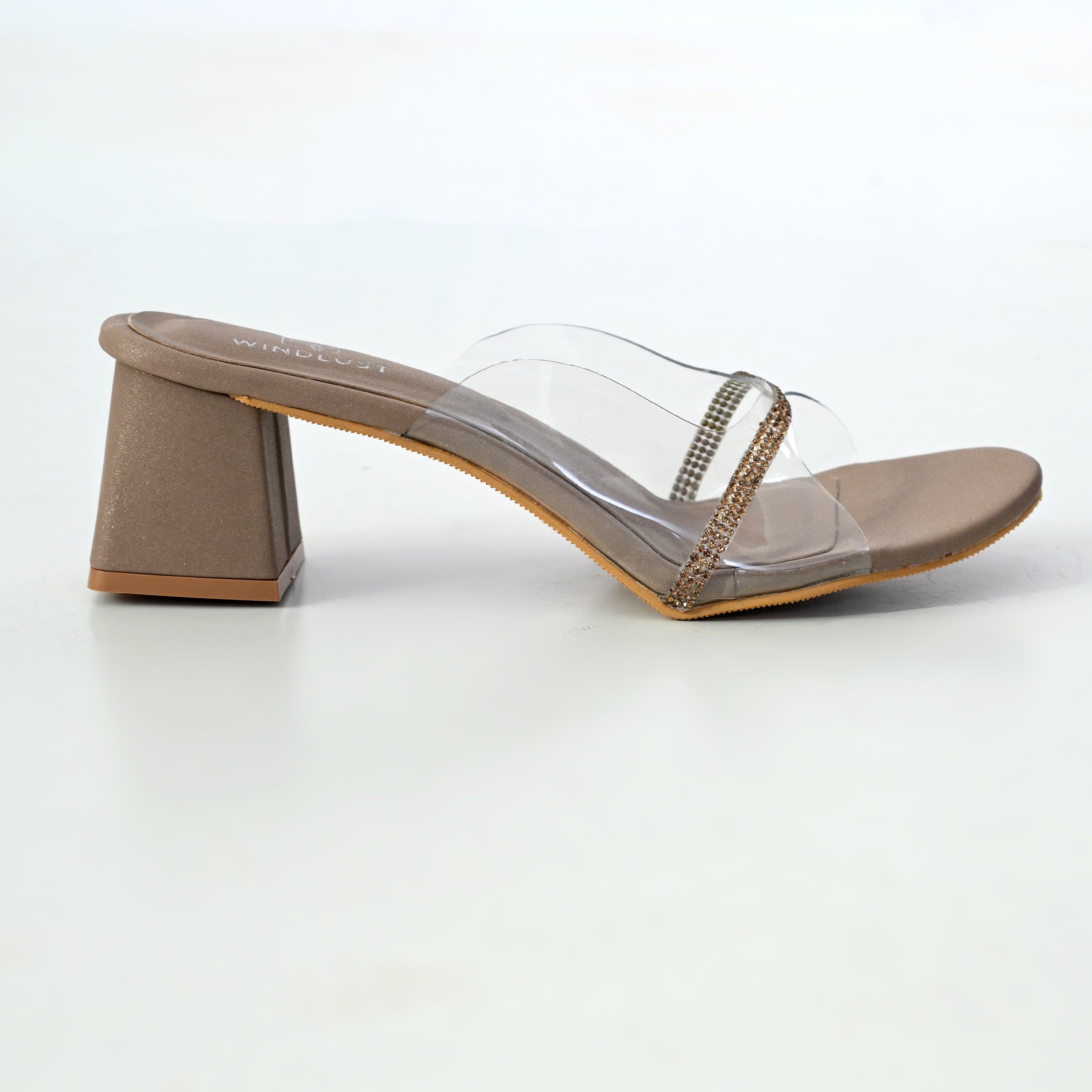 Clear Swarovski line heels in taupe by Windlust, featuring elegant transparent straps and sparkling crystal accents.