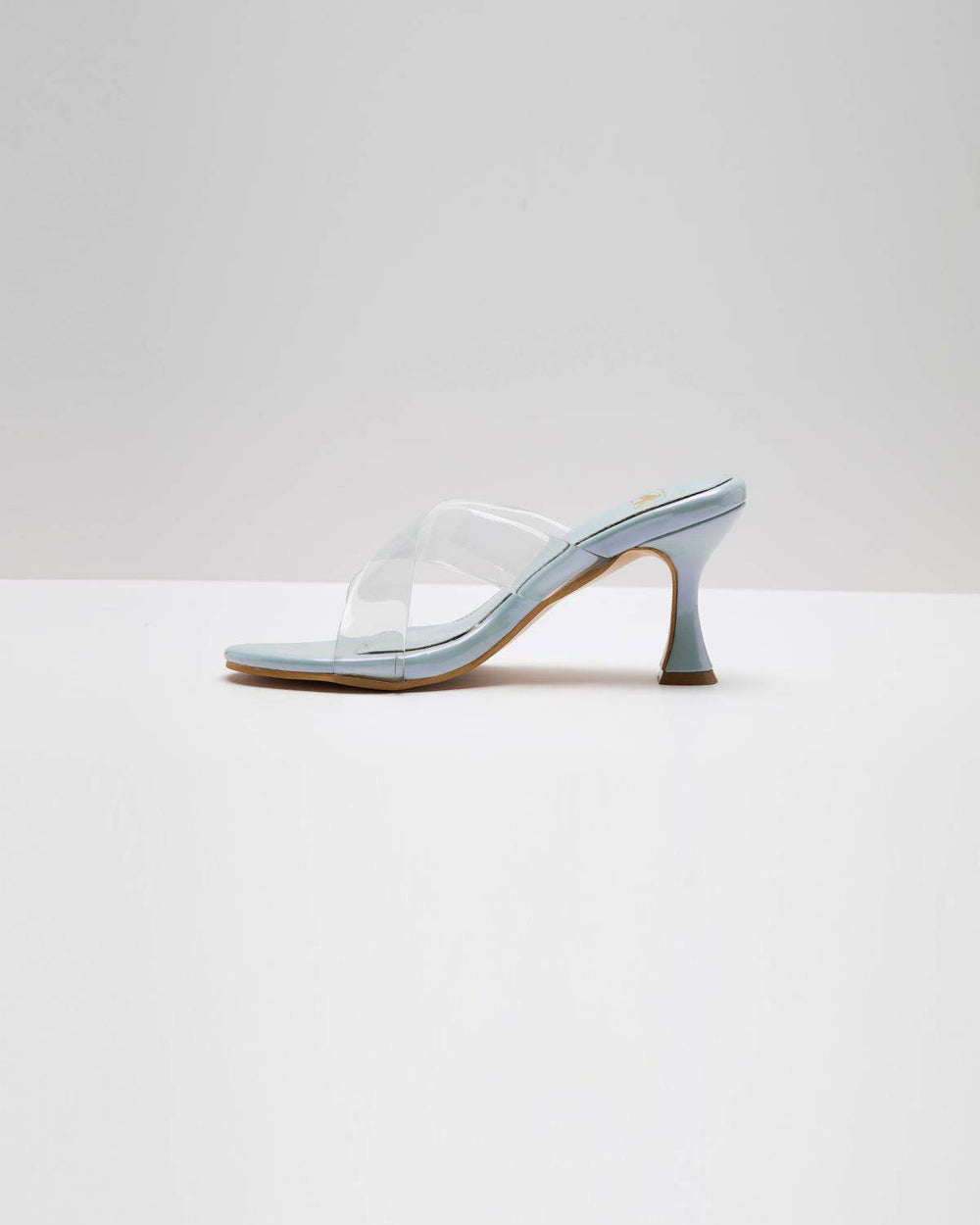 Light metallic blue transparent cross-strapped pumps by Windlust, stylish high heels with a sleek design.