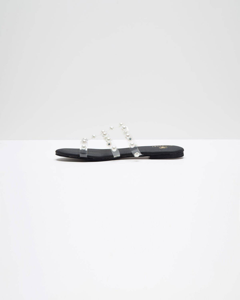 Black flats with three straps and pearl embellishments by Windlust, featuring a sleek, stylish design perfect for casual or dressy occasions.