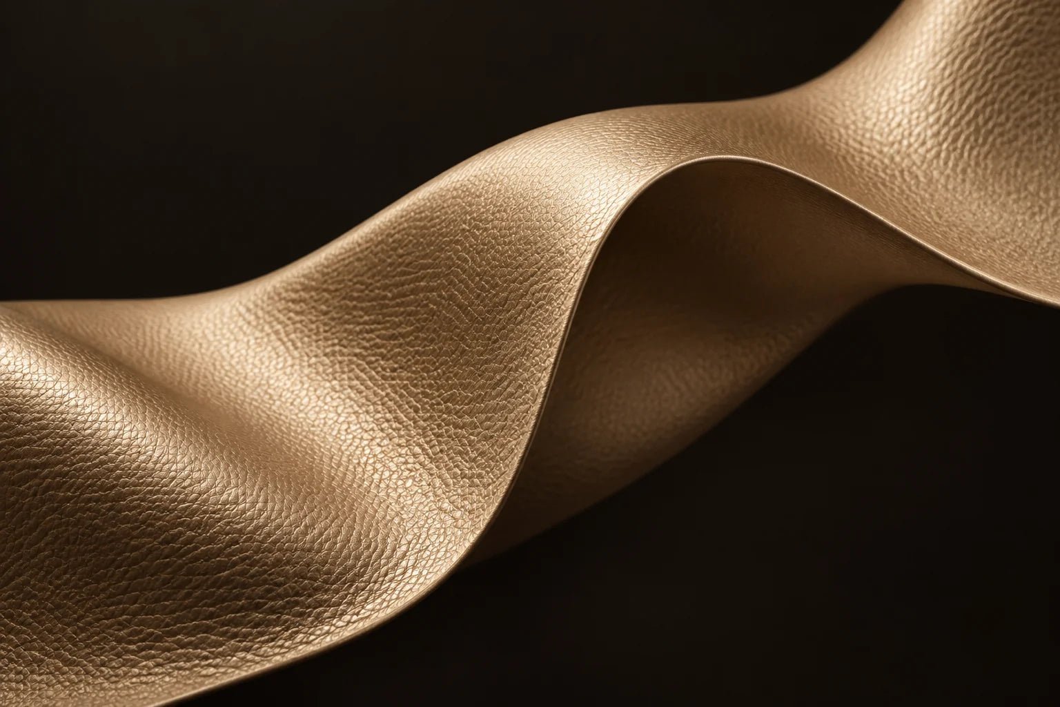 Conceptual macro study of a thin, supple champagne vegan-leather sheet.